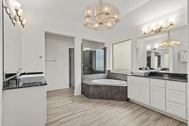 a spacious bathroom with a double vanity sink a mirror and a shower