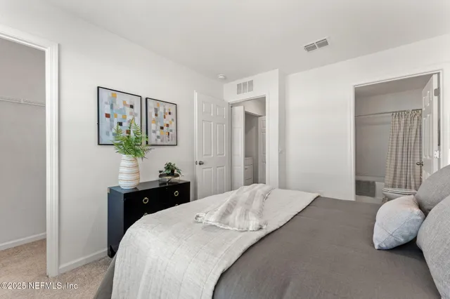 a bedroom with a bed and painting on the wall