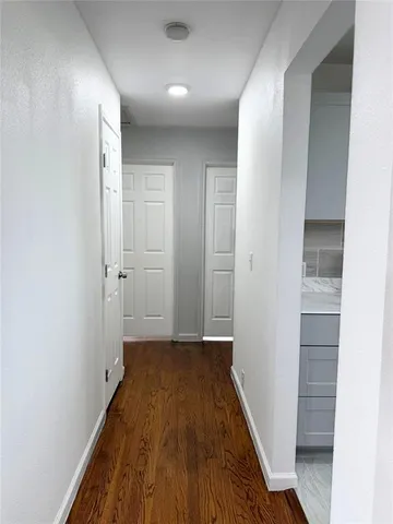 a view of a room with wooden floor and a hallway