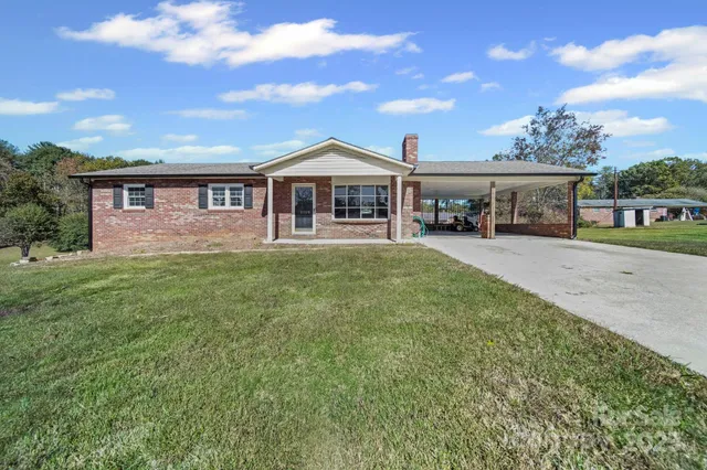a front view of a house with a yard and trees