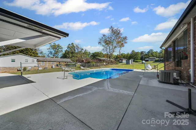 a view of swimming pool with a patio and a yard