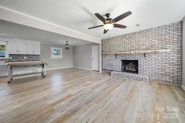 a view of empty room with wooden floor and fireplace