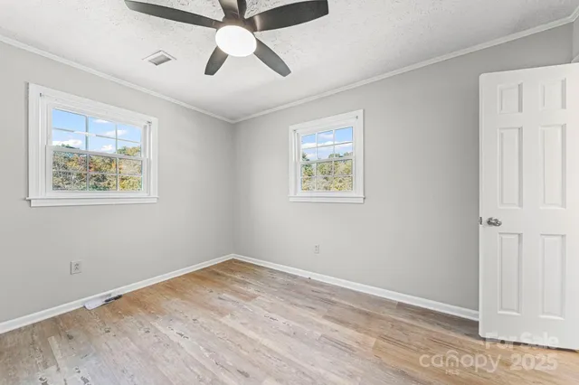 a view of empty room with wooden floor