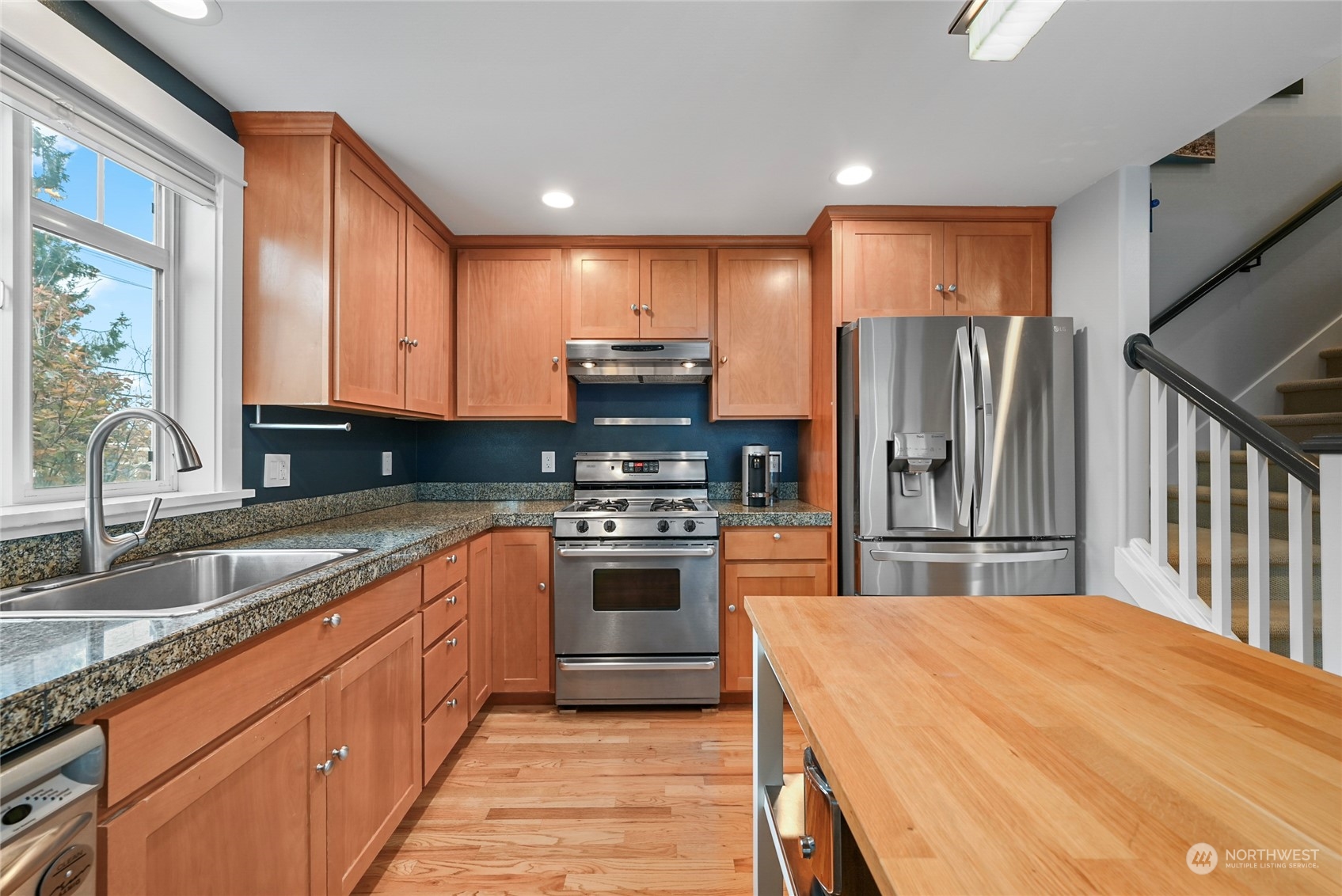 4408 Meridian Avenue North, Unit A Seattle, WA 98103 - Photo 6 of 31 a kitchen with stainless steel appliances granite countertop a refrigerator sink and cabinets