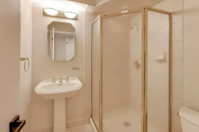 a spacious bedroom with a bed and a chandelier