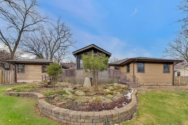 a backyard of a house with large trees and wooden fence