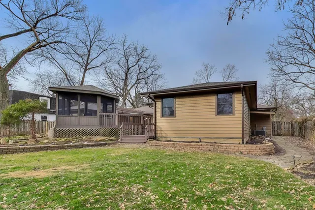 a view of a yard in front of a house with large trees