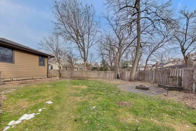 a view of a small house with a yard and large tree