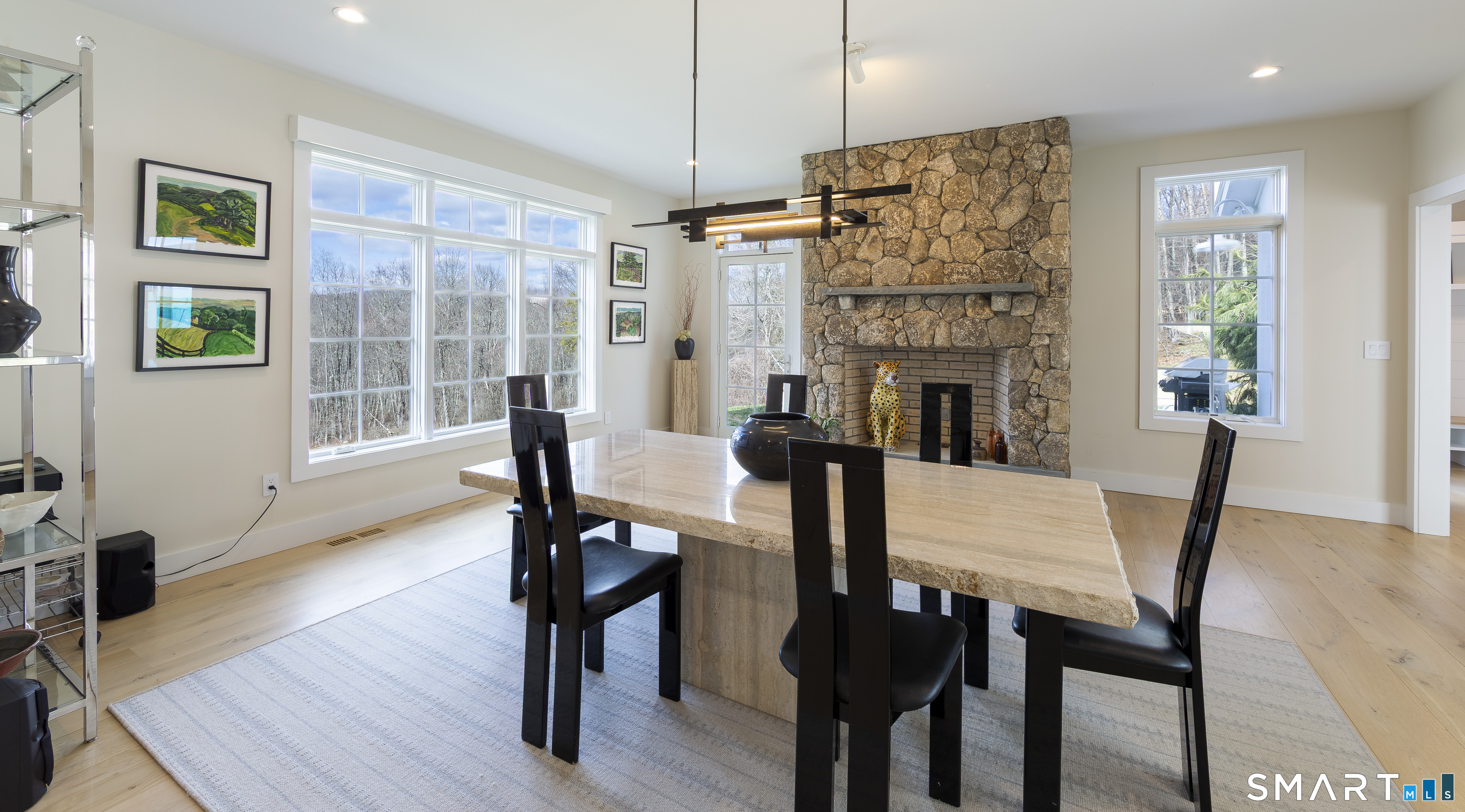 5 Upland Pastures Road Sherman, CT 06784 - Photo 17 of 40 The adjoining dining room, anchored by a floor-to-ceiling stone fireplace and access to a side patio, offers flexibility as either a formal gathering space or a relaxed family room.