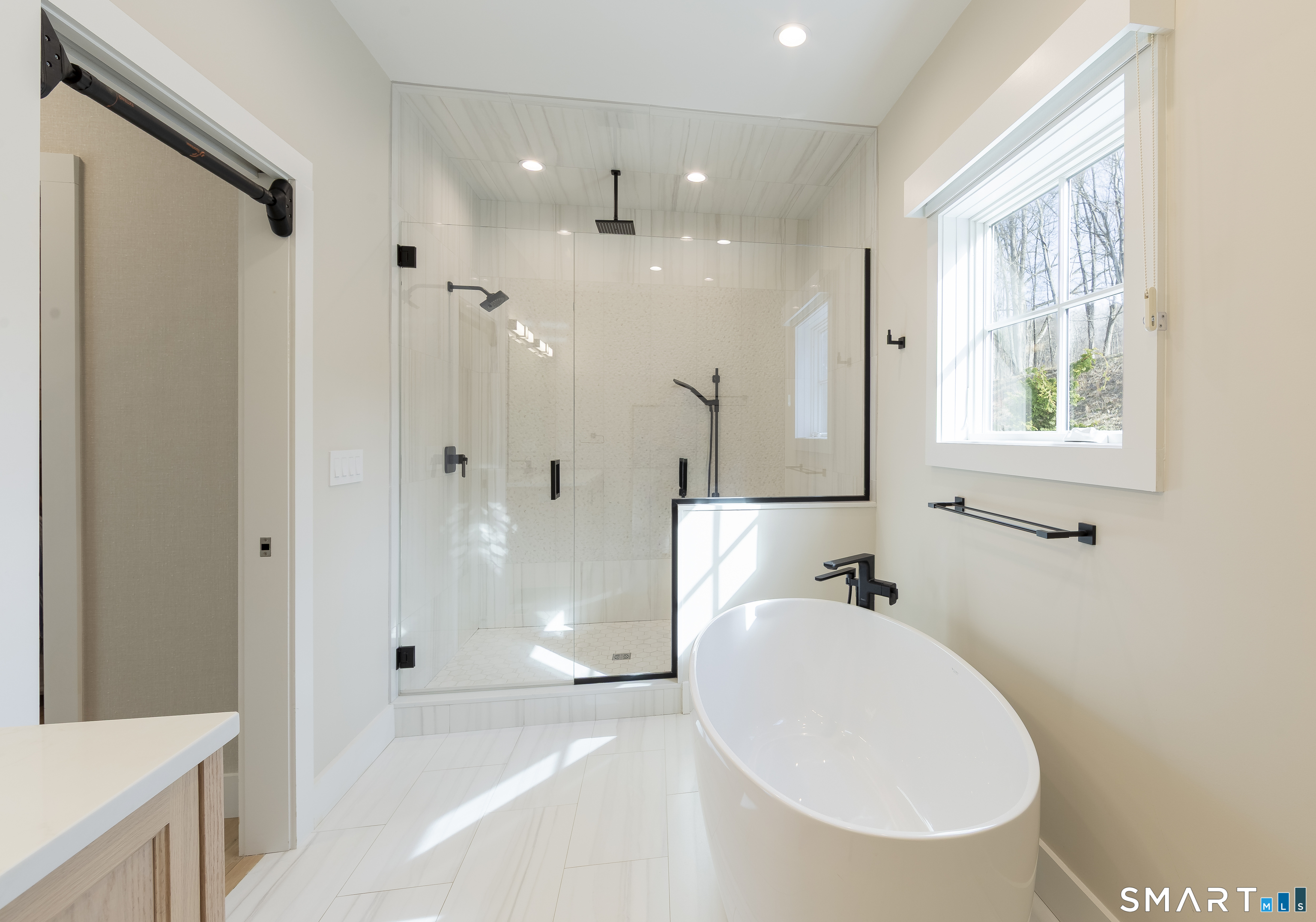 5 Upland Pastures Road Sherman, CT 06784 - Photo 21 of 40 Freestanding soaking tub, glass enclosed tiled walk-in shower with bench seating, rain shower head, shower head and hand shower.