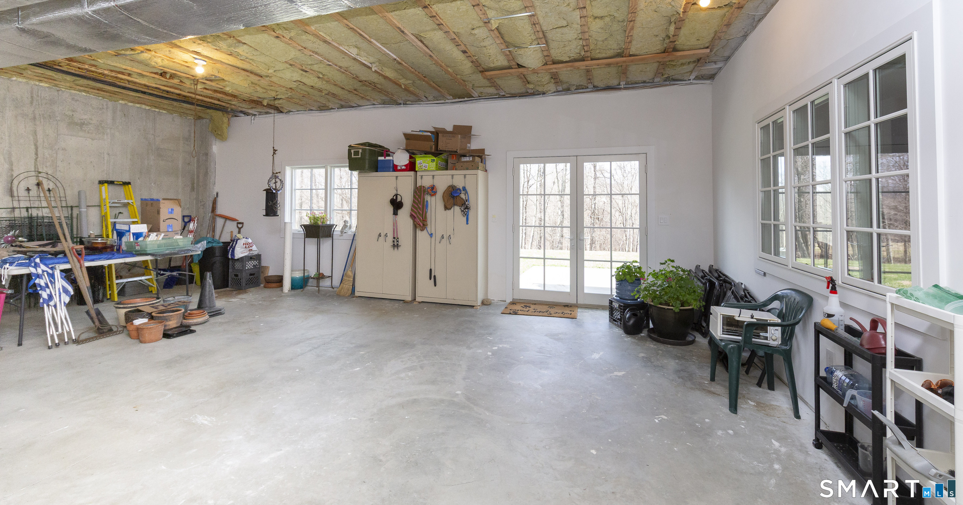 5 Upland Pastures Road Sherman, CT 06784 - Photo 37 of 40 Unfinished portion of the main home with double windows, French doors and on the other side, Speed Queen washer and dryer.