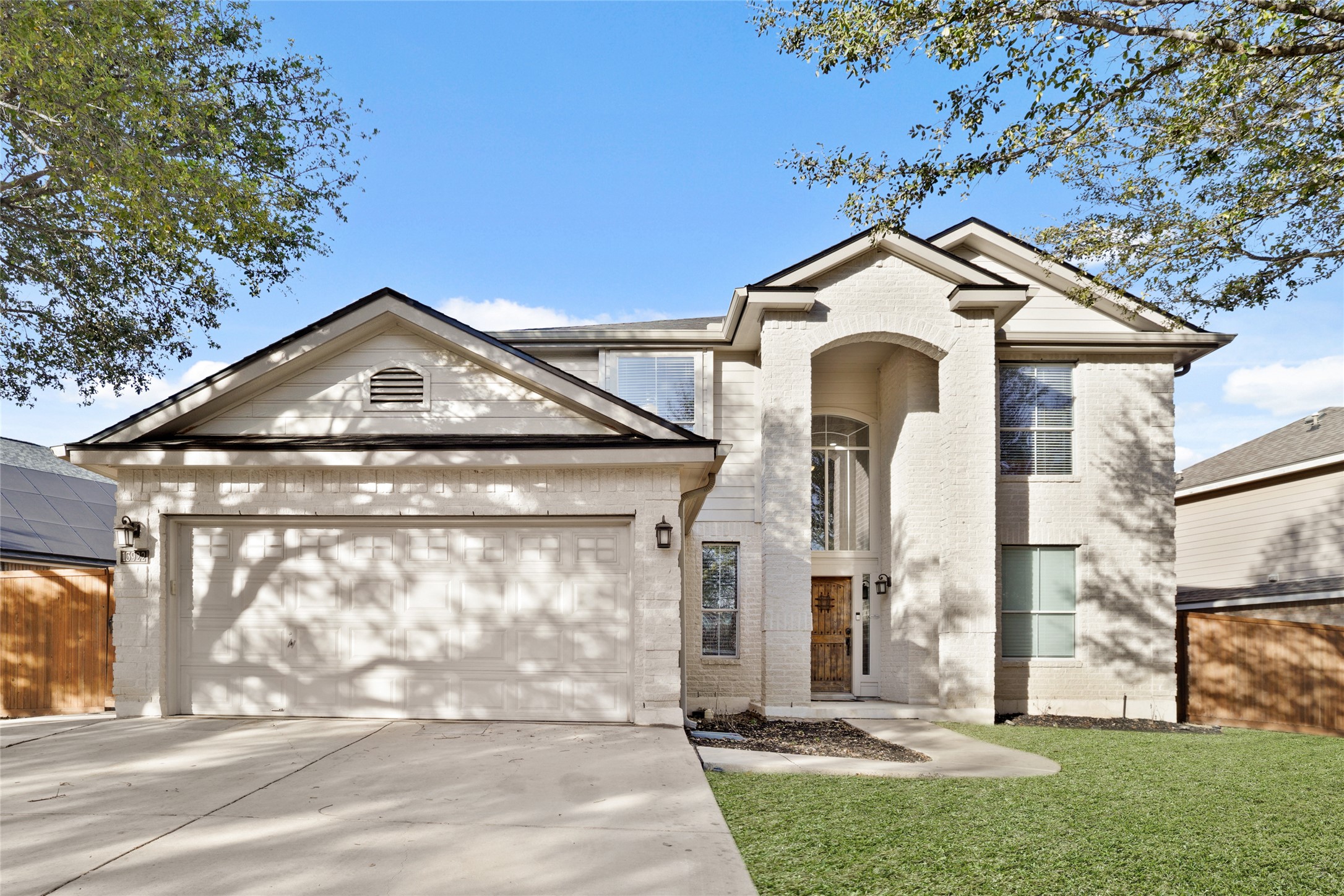 13922 Jubilee Way Helotes, TX 78023 - Photo 1 of 27 View of front facade featuring brick, a 2 car garage, driveway, and a front yard