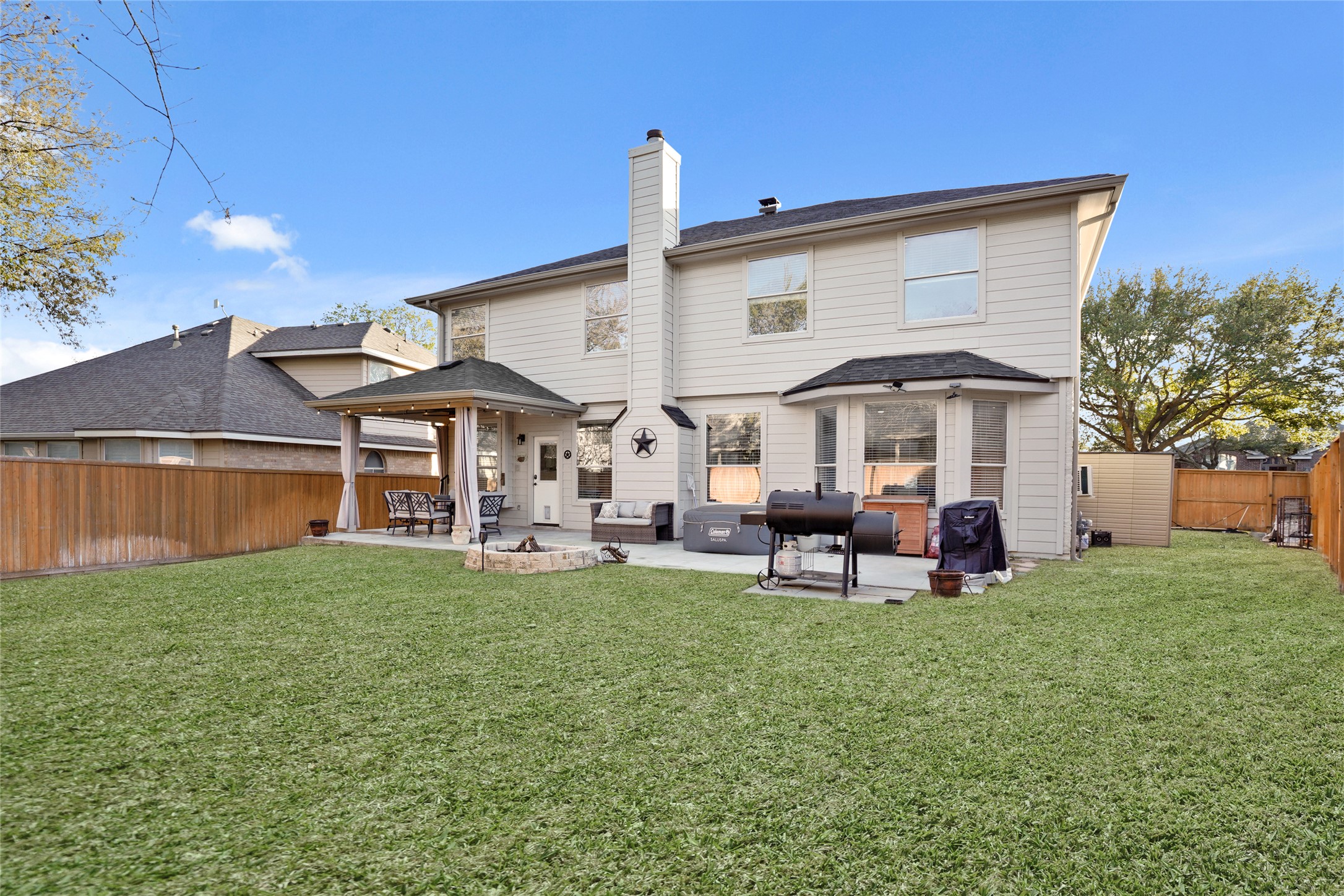 13922 Jubilee Way Helotes, TX 78023 - Photo 21 of 27 Back of property with a chimney, a patio area, a fenced backyard, and a shingled roof