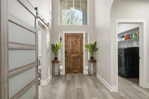 a view of a hallway view with wooden floor and entryway