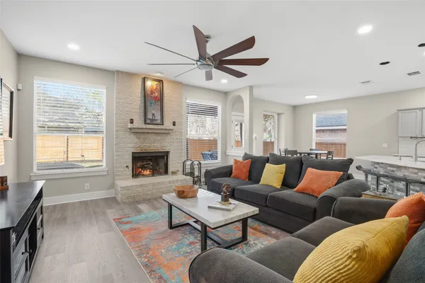 a living room with furniture a ceiling fan and a fireplace