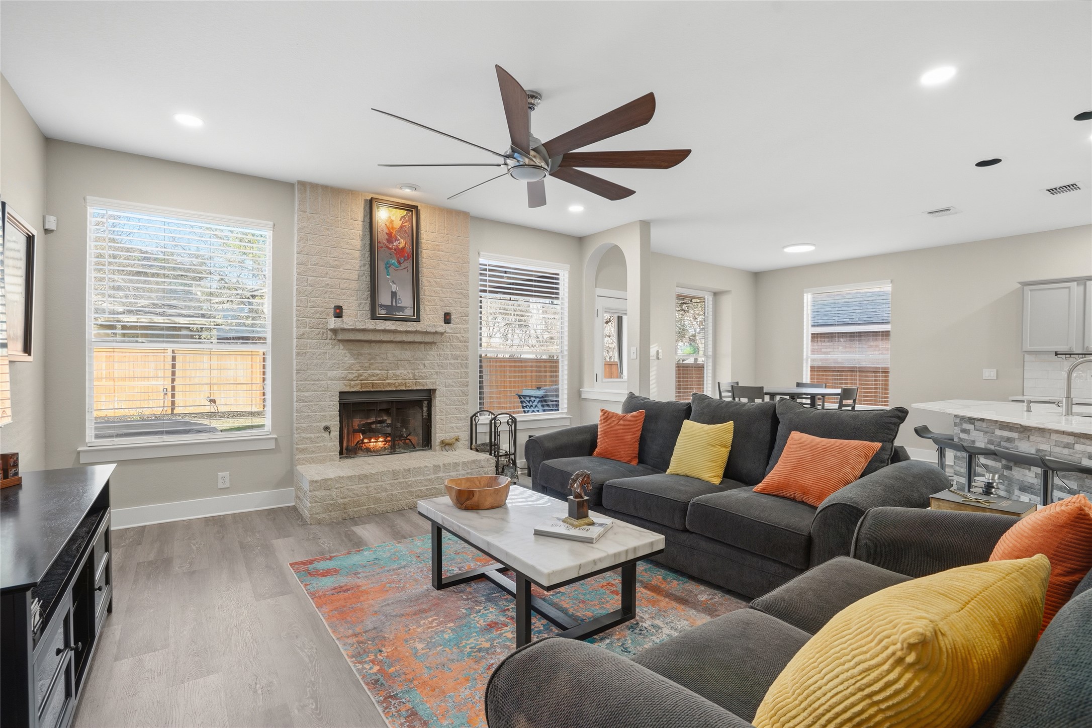 13922 Jubilee Way Helotes, TX 78023 - Photo 7 of 27 Living area with a ceiling fan, light wood-style flooring, a brick wood burning fireplace, and recessed lighting