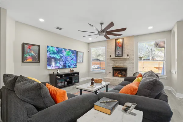a living room with furniture a fireplace and a large window