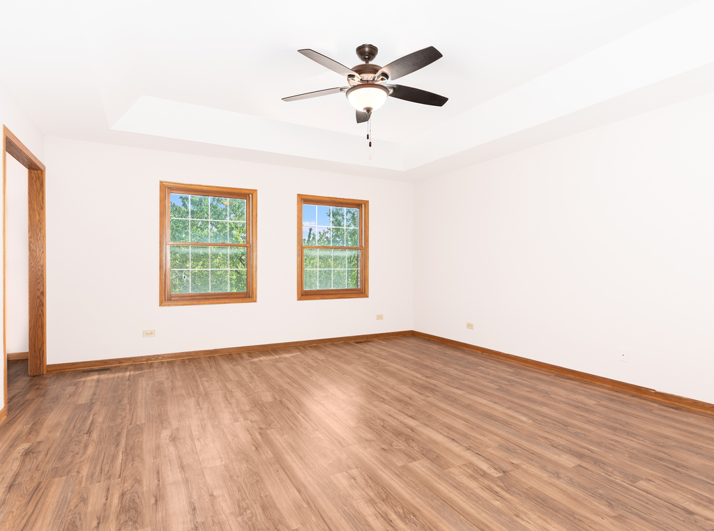 21322 Georgetown Road Frankfort, IL 60423 - Photo 14 of 28 an empty room with wooden floor ceiling fan and windows