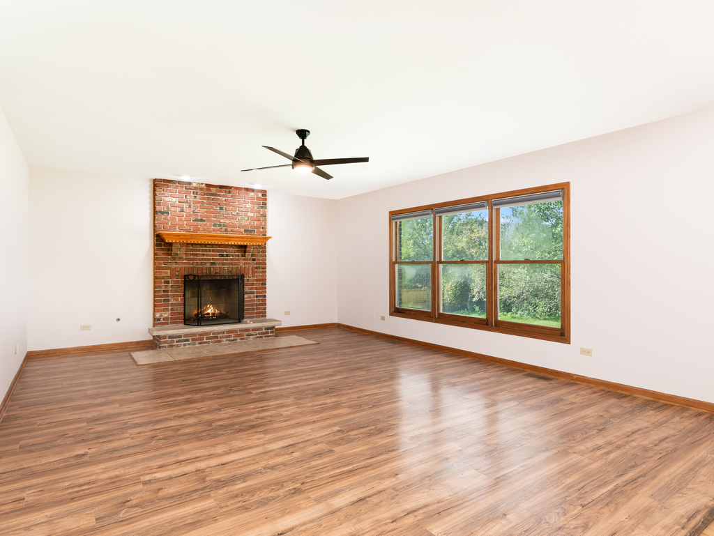 21322 Georgetown Road Frankfort, IL 60423 - Photo 6 of 28 a view of an empty room with wooden floor fireplace and a window