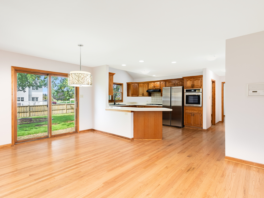21322 Georgetown Road Frankfort, IL 60423 - Photo 8 of 28 a kitchen with stainless steel appliances kitchen island wooden cabinets and a fireplace