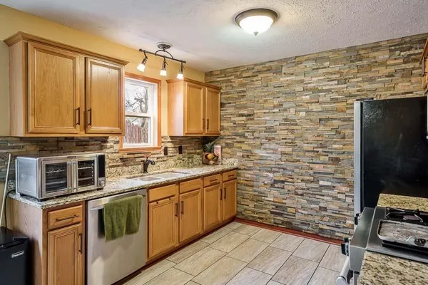 a kitchen with stainless steel appliances wooden cabinets and a stove top oven