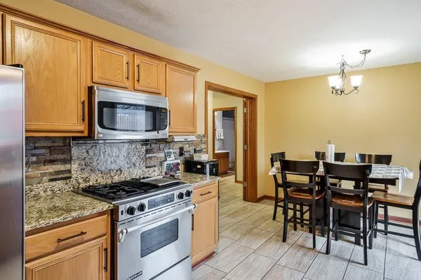 a kitchen with a stove a sink and chairs