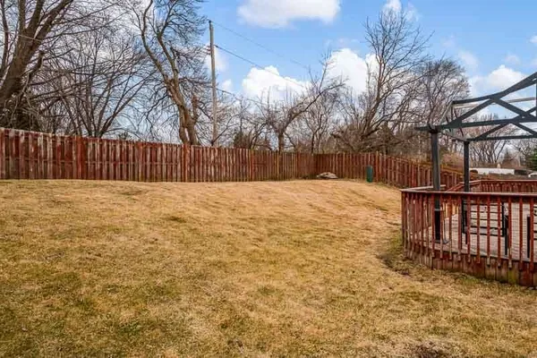 a view of backyard with wooden fence