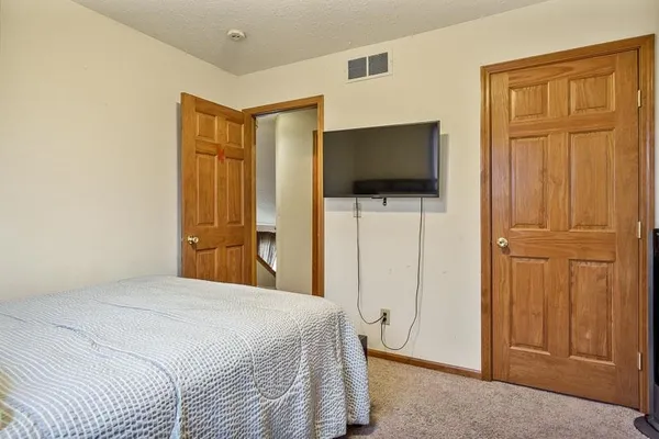 a bedroom with a bed and a flat screen tv