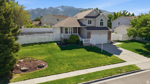 11189 Ohenry Road East Sandy, UT 84070 - Photo 40 of 44 Two-story residence featuring a covered front porch with white railing, a two-car garage, and a concrete driveway
