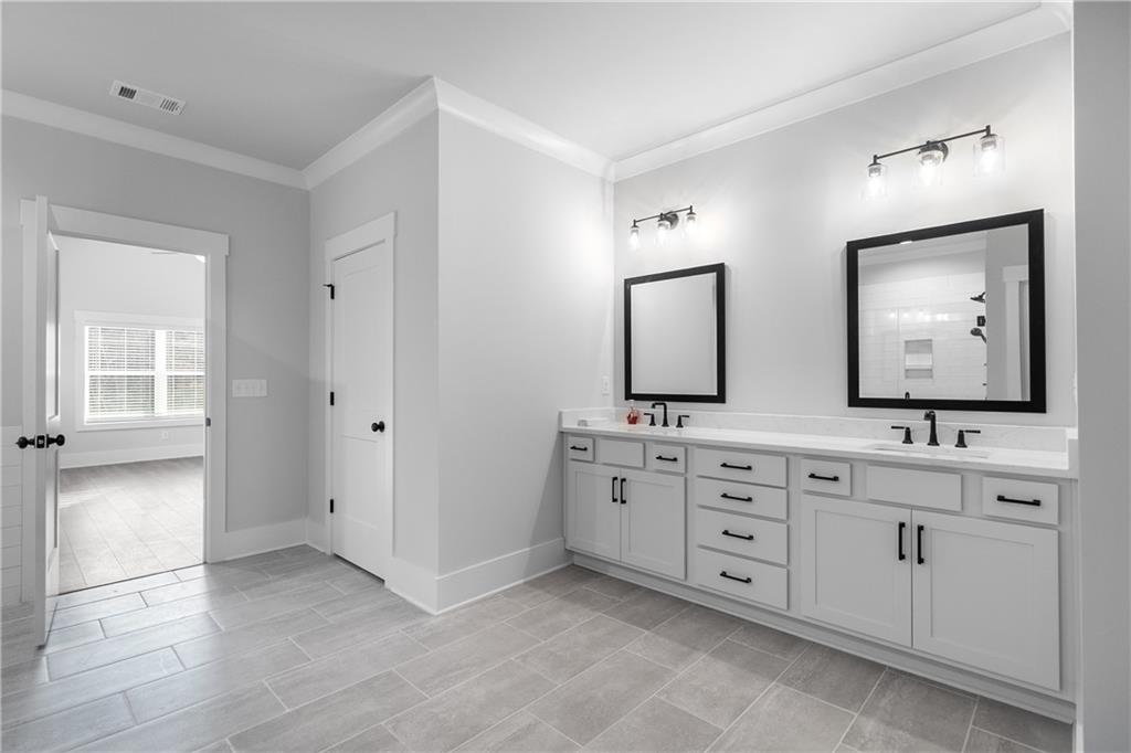 2321 Pebble Trail Monroe, GA 30656 - Photo 18 of 21 a spacious bathroom with double vanity sinks and a large mirror