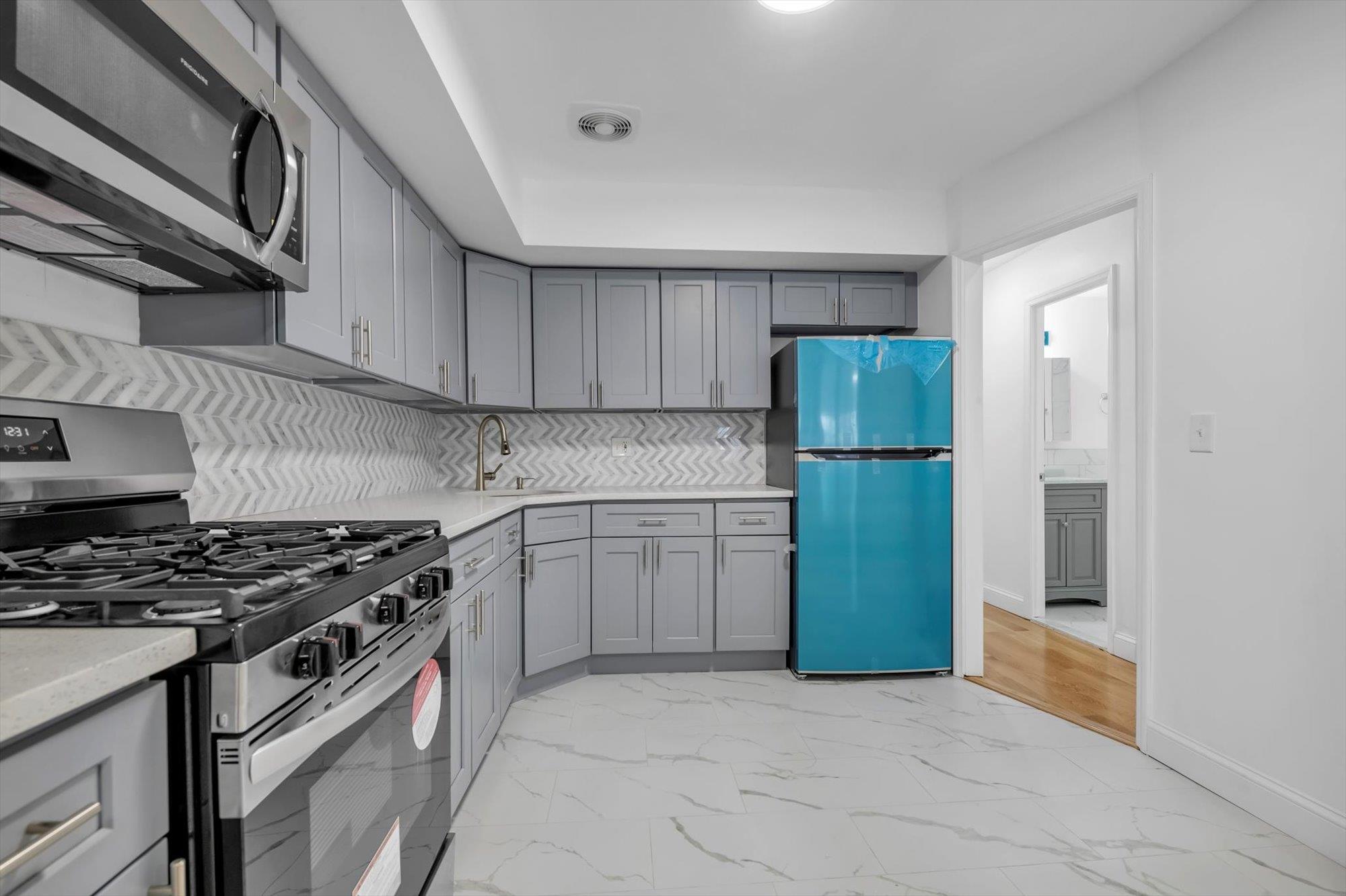 a kitchen with a stove a refrigerator and a cabinets