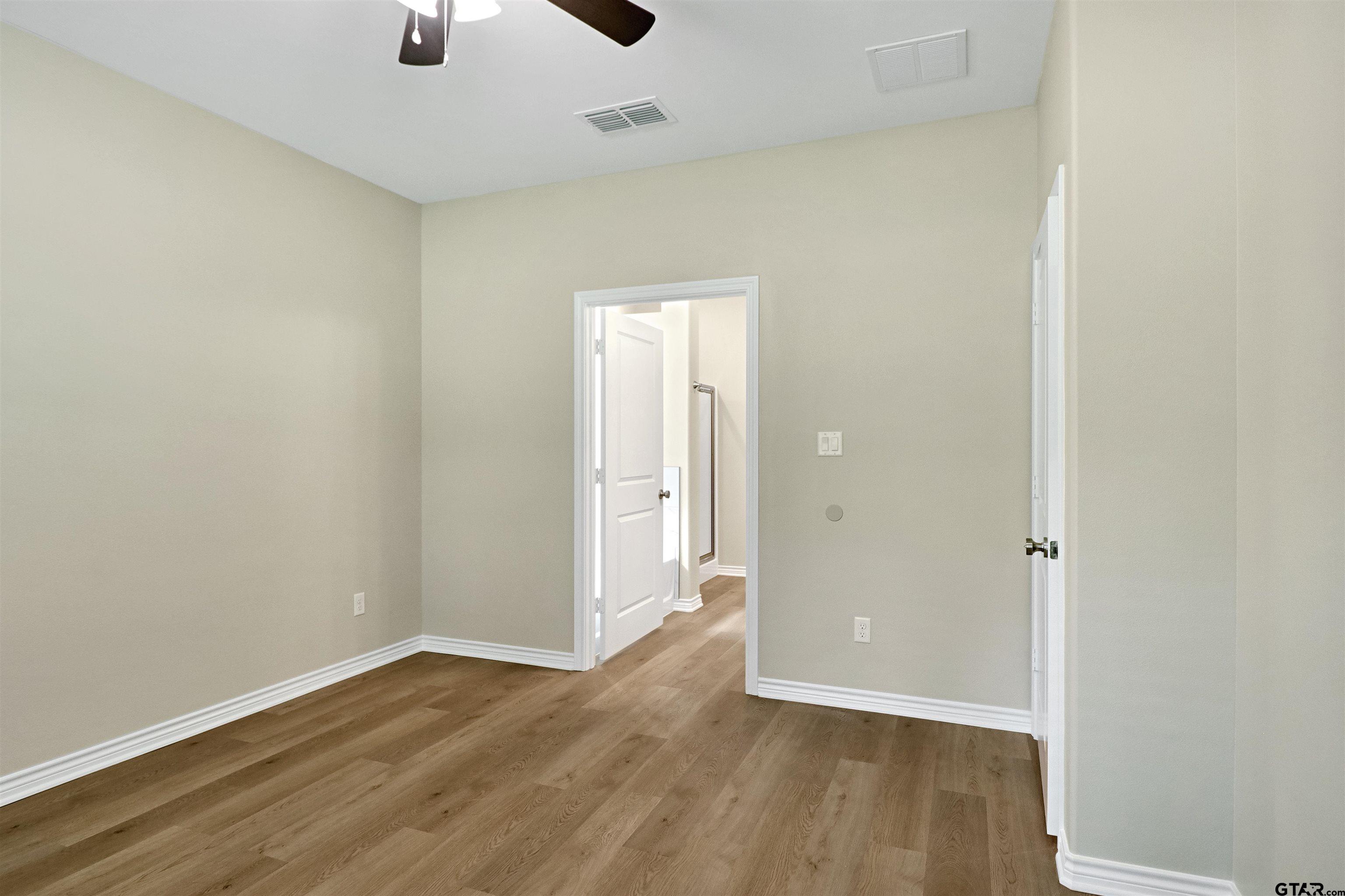 3053 Guinn Farms Road Tyler, TX 75707 - Photo 18 of 32 an empty room with wooden floor and windows