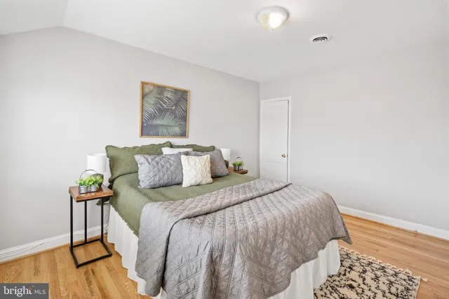 a bedroom with bed and wooden floor