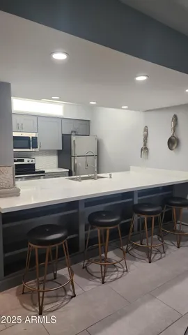 a kitchen with a table chairs sink and cabinets