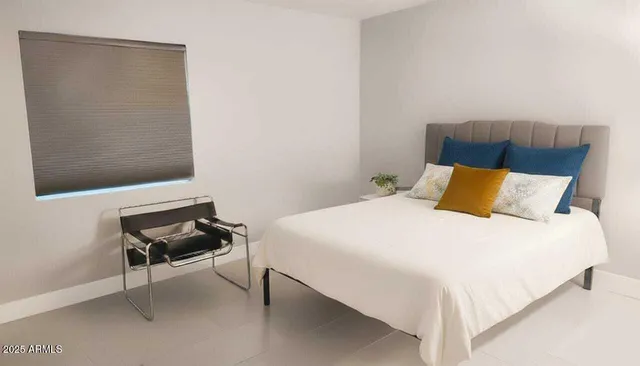 a bedroom with a bed and a chair