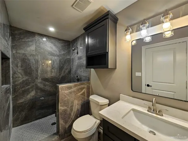 a bathroom with a sink toilet a mirror and shower