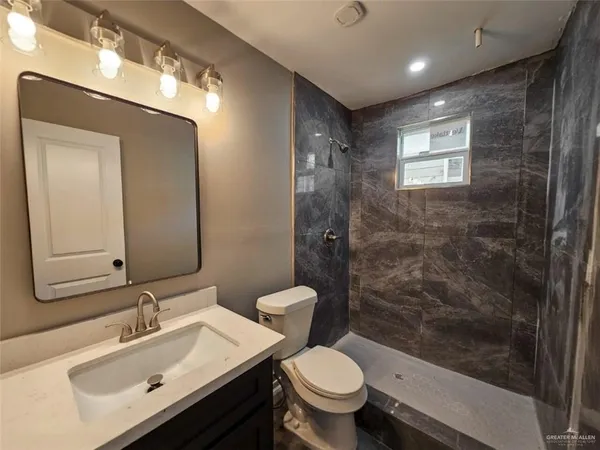 a bathroom with a sink toilet a mirror and shower