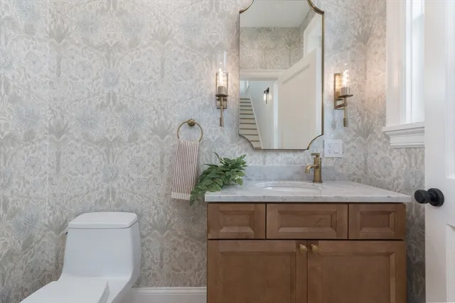 a bathroom with a granite countertop sink a toilet and a mirror