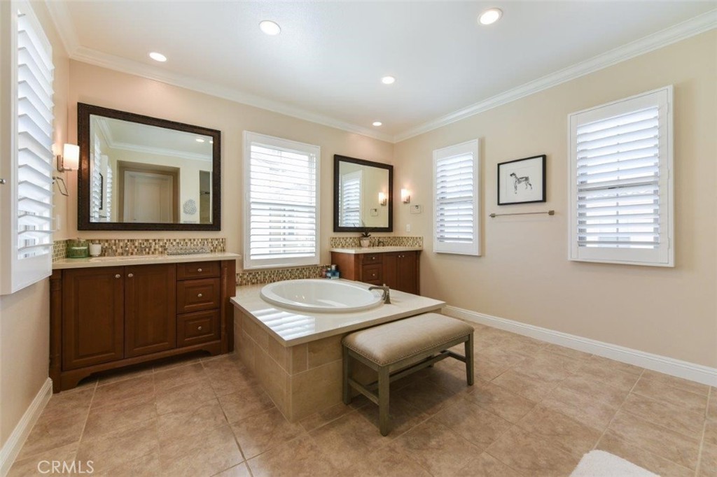 62 Rossmore Irvine, CA 92620 - Photo 19 of 43 a spacious bathroom with a granite countertop sink a mirror and a bathtub