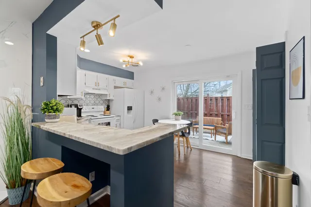 a view of kitchen island a sink wooden floor and living room view