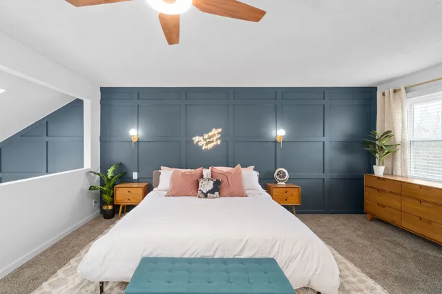 a bedroom with a bed a lamp and window