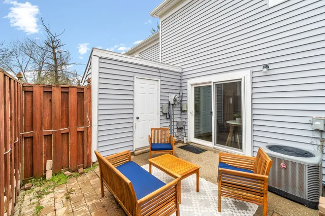 a backyard of a house with barbeque oven table and chairs
