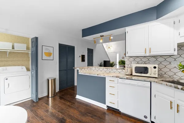 a kitchen with cabinets and wooden floor