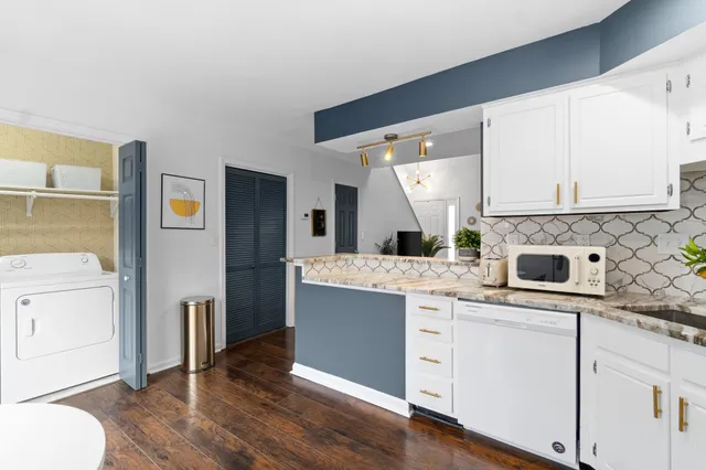 a kitchen with cabinets and wooden floor