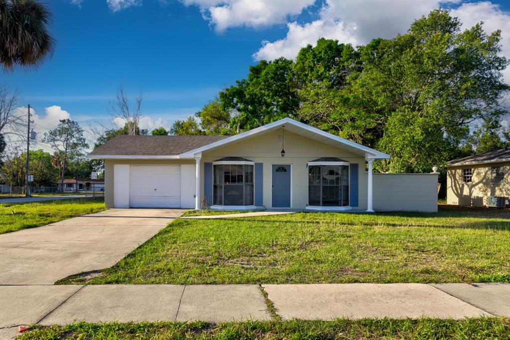 a front view of house with yard and garage