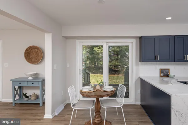 a kitchen with a table chairs and a wooden floor