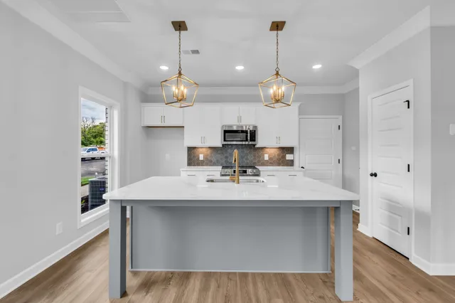 a view of dining table chairs wooden floor and kitchen view