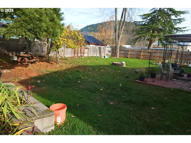 a view of backyard with outdoor seating and wooden fence