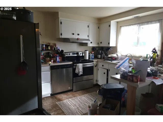 a kitchen with a stove a refrigerator and a window