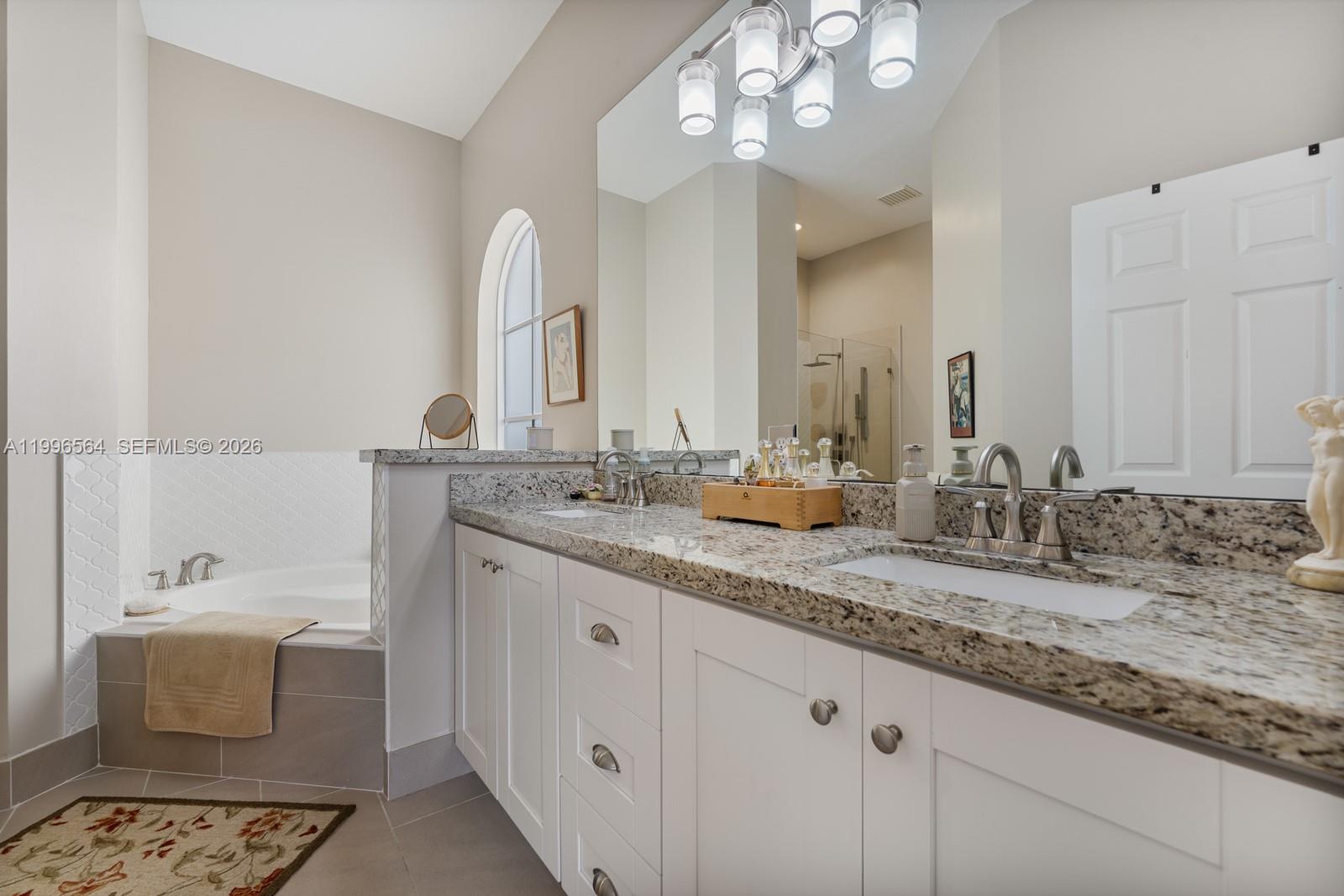 9473 Southwest 227th Terrace Cutler Bay, FL 33190 - Photo 13 of 31 a bathroom with a granite countertop sink a large mirror and vanity